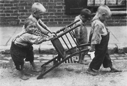 Children in Deptford playing with a chair (https://it.pinterest.com/pin/409123947385170658/)